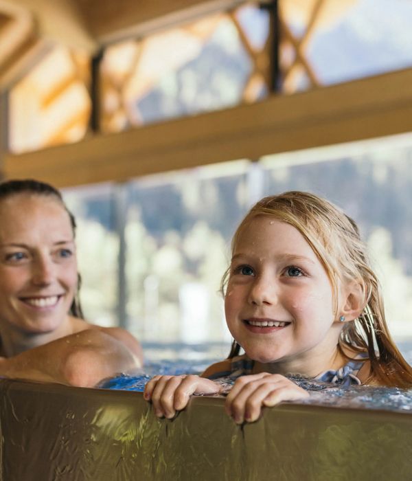 Mutter und Tochter am Rand des Infinity-Pools im Feelfree Badhaus